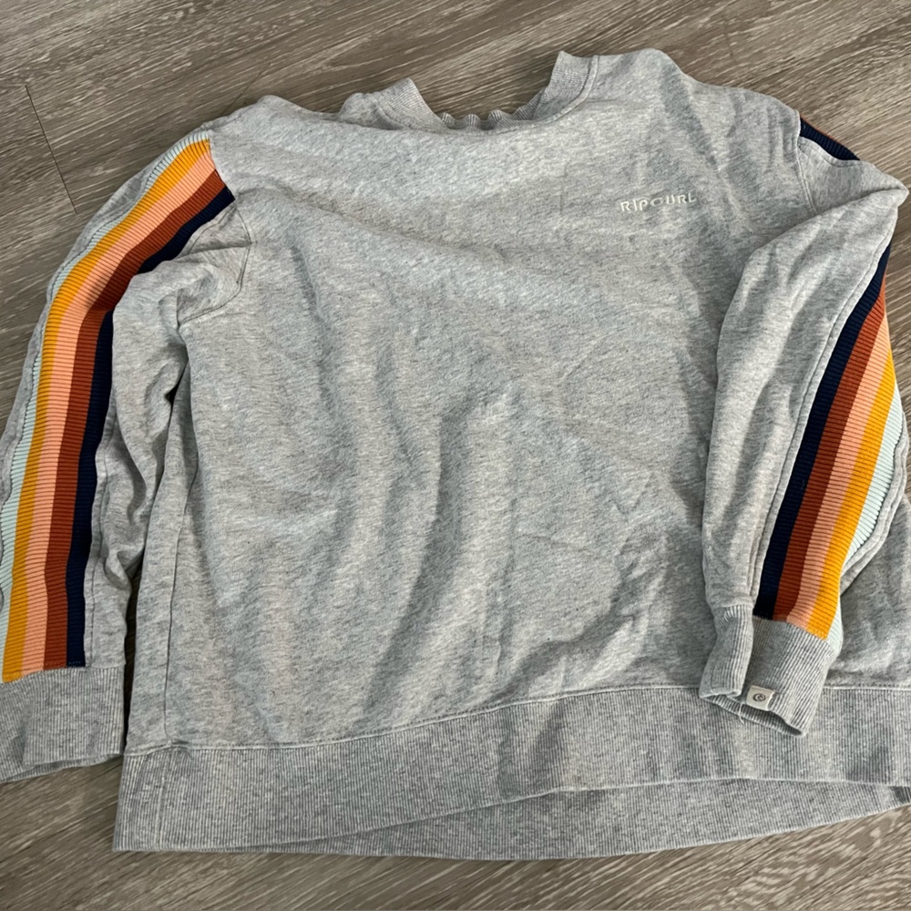 Grey medium rip curl sweater/crew neck with rainbow stripes down the side